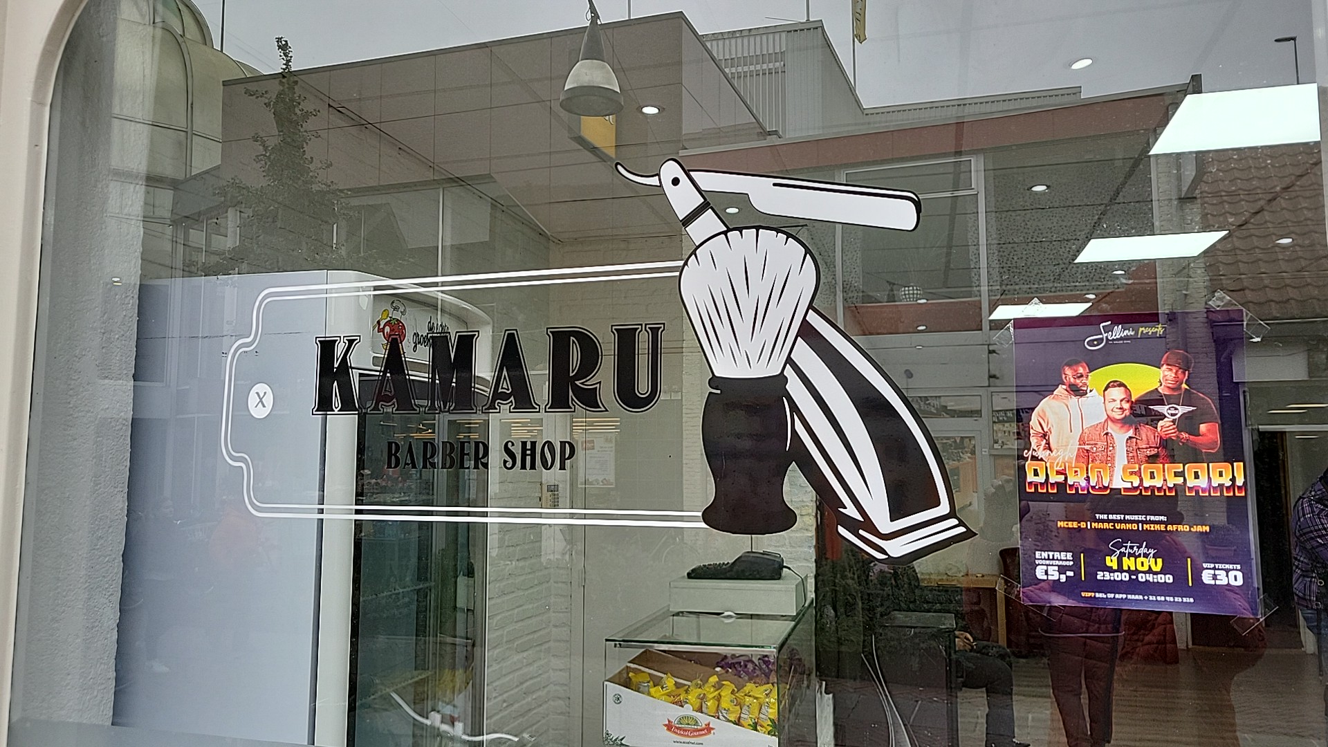 Het Kamaru Barber Shop raamlogo met scheermes en scheerkwast