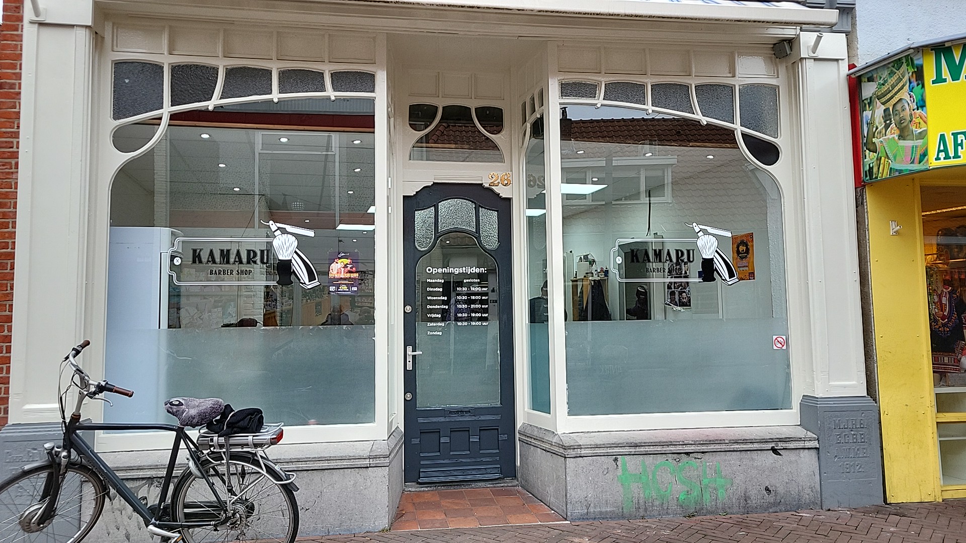 De gevel van Kamaru Barber aan De Heurne, met de naam op beide ramen